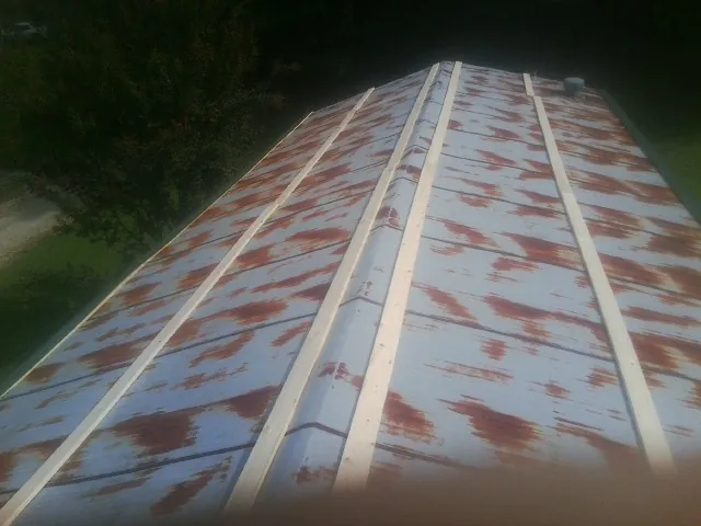 Rusted metal roof panels with new wood purlins before replacement — Storm Damage Roof Repair in Ida by Roofing Brothers