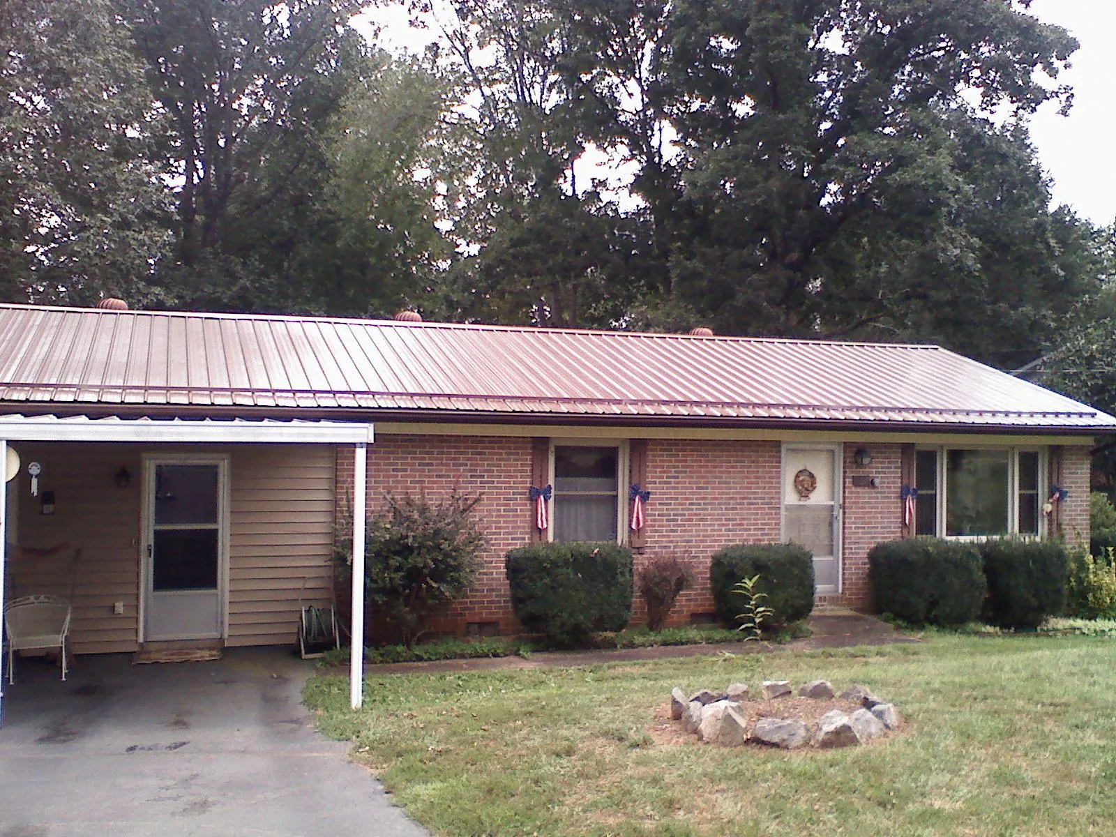 Bronze metal roof and carport on a brick ranch home — Roof Repair work by our crew in Ida